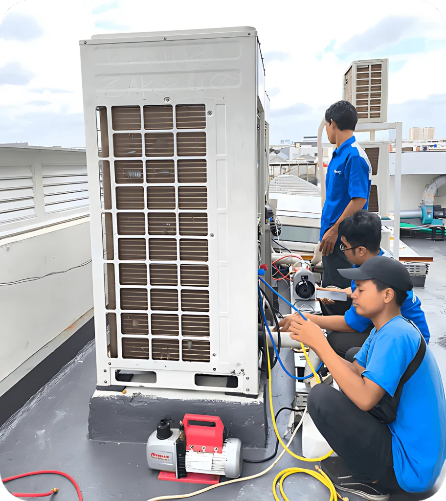 Teknisi Sampurna Jaya Teknik AC sedang memperbaiki unit AC di atas gedung bersama rekan kerja dengan standar keselamatan kerja profesional